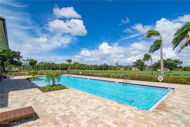 pool with a patio and fence