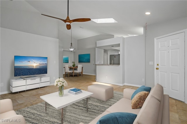 living room featuring vaulted ceiling with skylight and ceiling fan