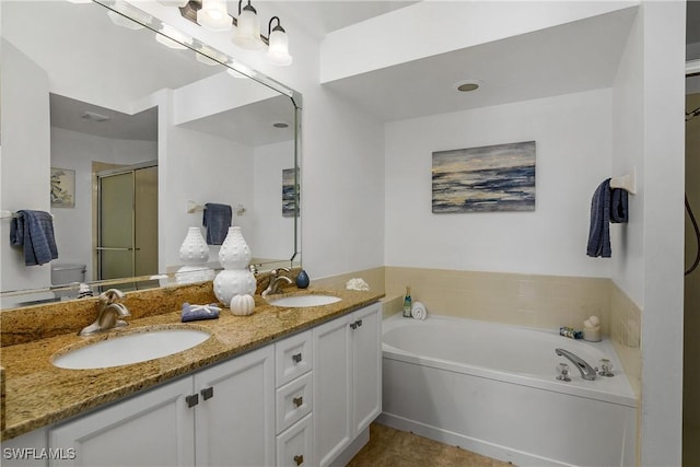 bathroom featuring double vanity, a sink, a bath, and a shower stall