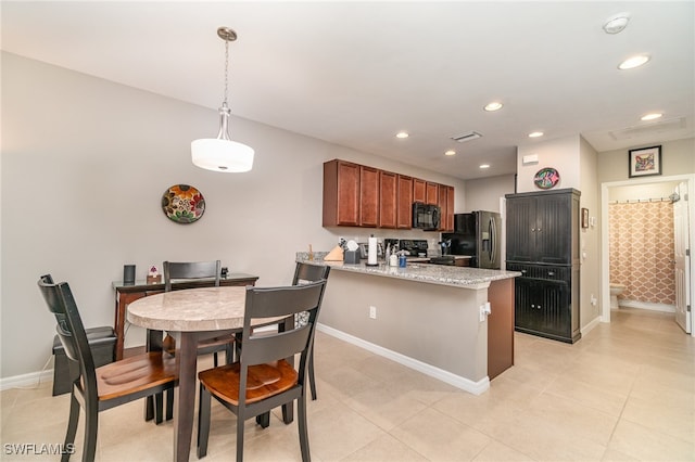 kitchen with light stone countertops, hanging light fixtures, kitchen peninsula, light tile patterned floors, and black appliances