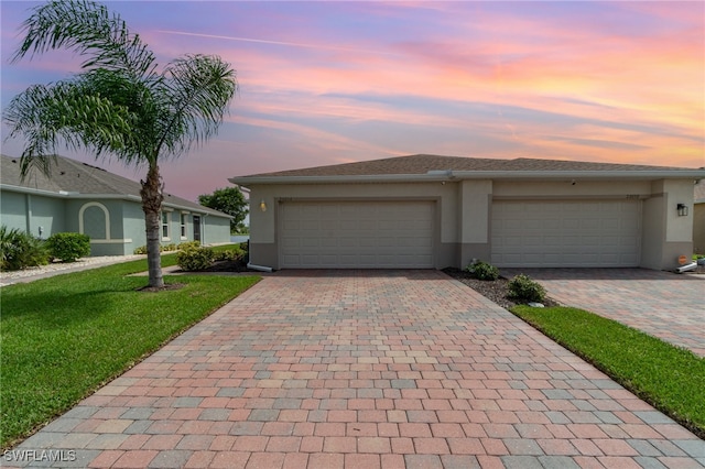 view of front of house with a garage and a lawn