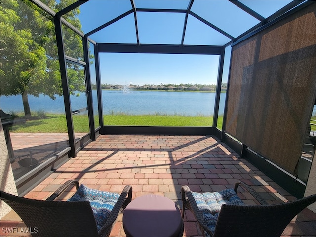 sunroom featuring vaulted ceiling and a water view