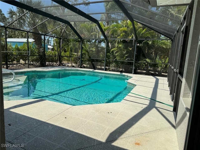 view of swimming pool with a lanai and a patio