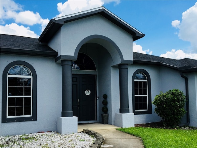 view of exterior entry featuring covered porch