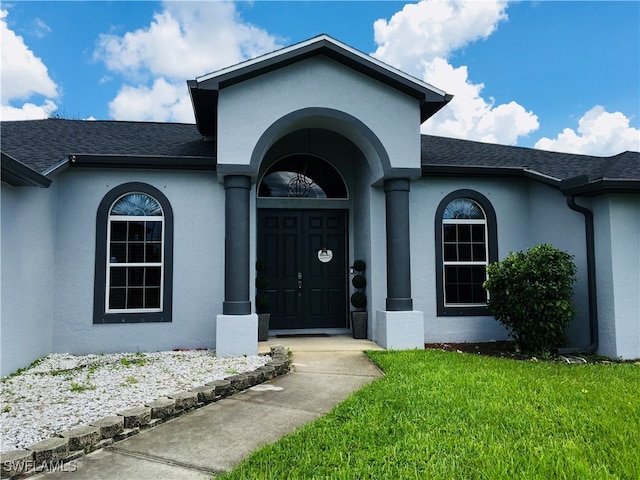 property entrance with a lawn