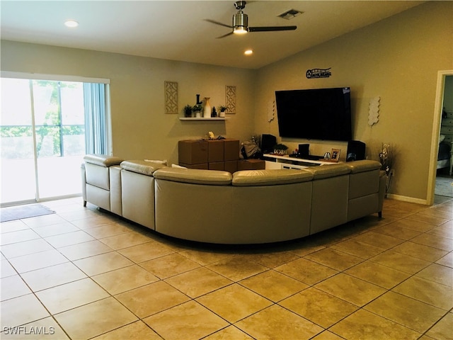 living room with ceiling fan, light tile patterned floors, and vaulted ceiling