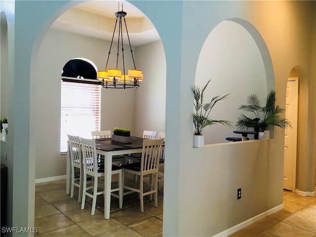 tiled dining space featuring a chandelier