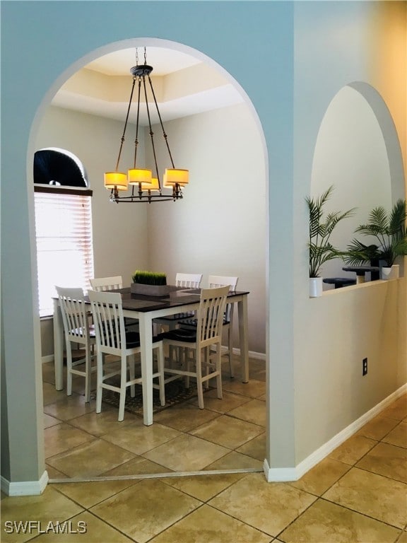 tiled dining space featuring an inviting chandelier