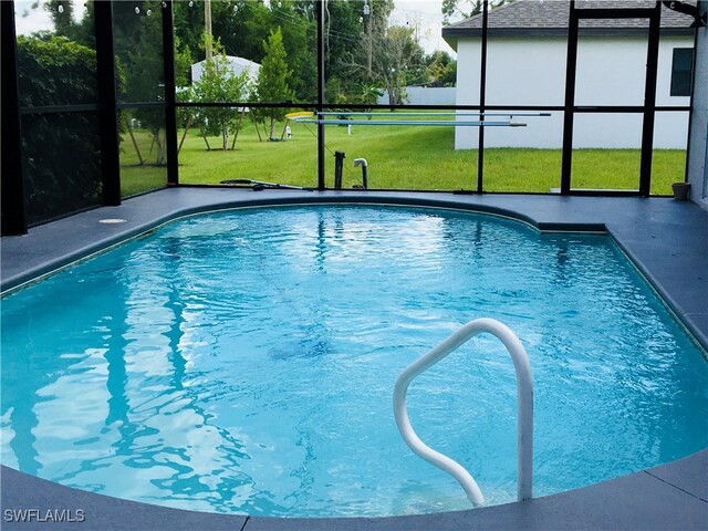 view of swimming pool with a lanai and a yard