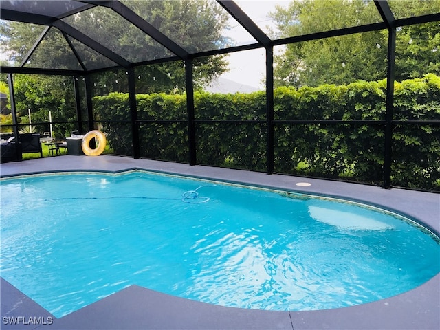 view of pool with glass enclosure