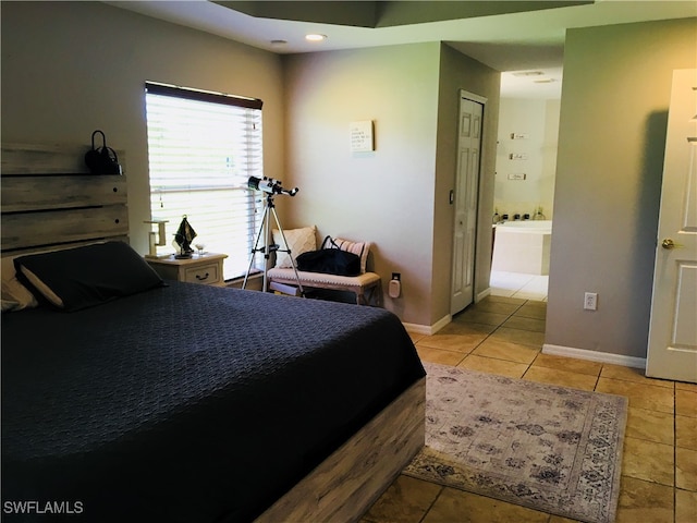 bedroom with a closet, light tile patterned floors, and connected bathroom