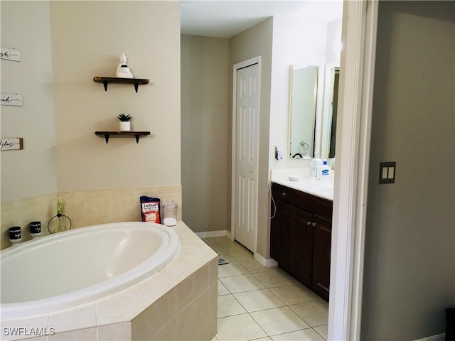 bathroom with tile patterned floors, a relaxing tiled tub, and vanity