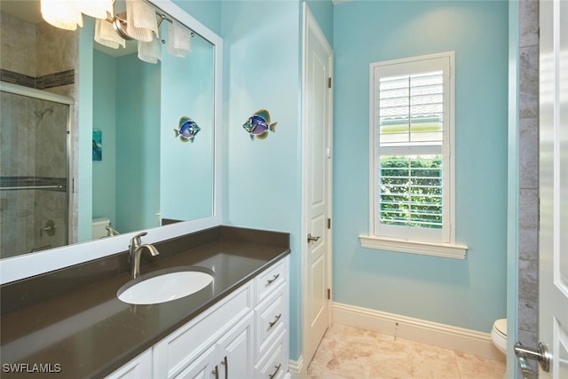 bathroom with vanity, toilet, tile patterned floors, and a shower with shower door