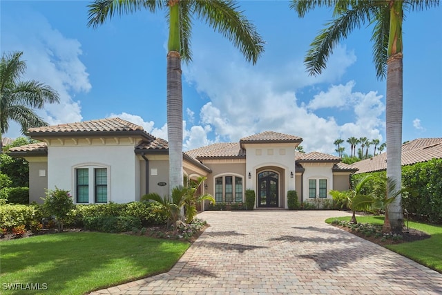 23778 Campla Ct, Estero, FL 34134 - mediterranean / spanish home featuring french doors, a tile roof, a front lawn, and stucco siding