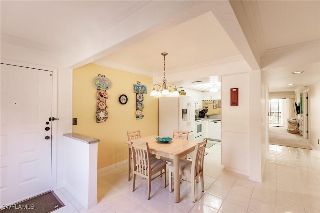 dining room with ornamental molding, light tile patterned floors, baseboards, and an inviting chandelier