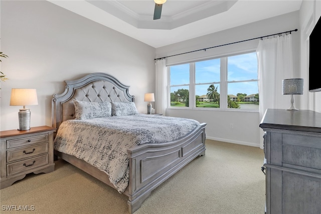 bedroom featuring crown molding, ceiling fan, light carpet, and a tray ceiling