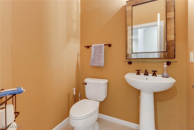 bathroom featuring tile patterned flooring, toilet, and sink