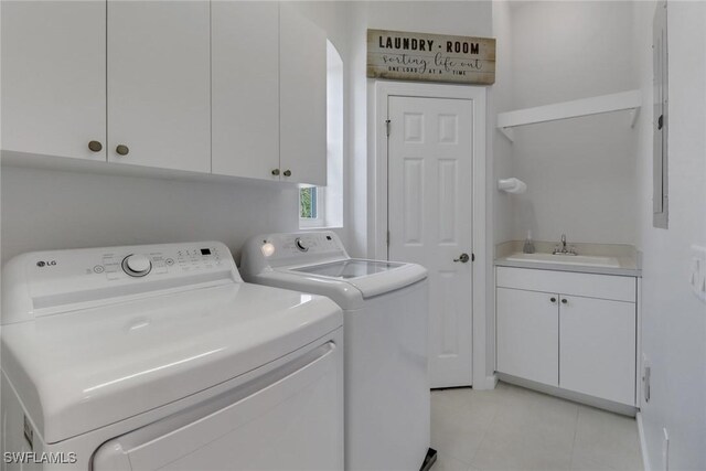 laundry room with light tile patterned flooring, sink, cabinets, and washing machine and dryer