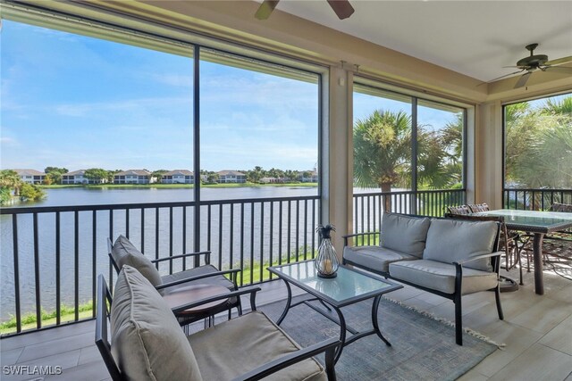 sunroom / solarium featuring a water view and ceiling fan