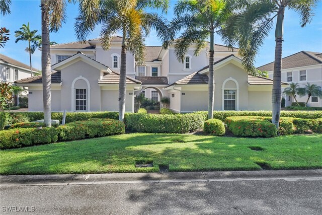 mediterranean / spanish-style home featuring a front yard