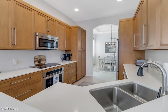 kitchen featuring appliances with stainless steel finishes, an inviting chandelier, light tile patterned flooring, and sink