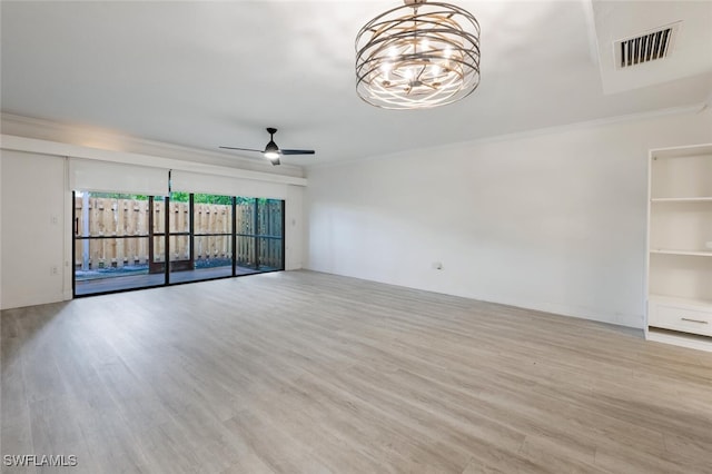 empty room with crown molding, visible vents, wood finished floors, and ceiling fan with notable chandelier