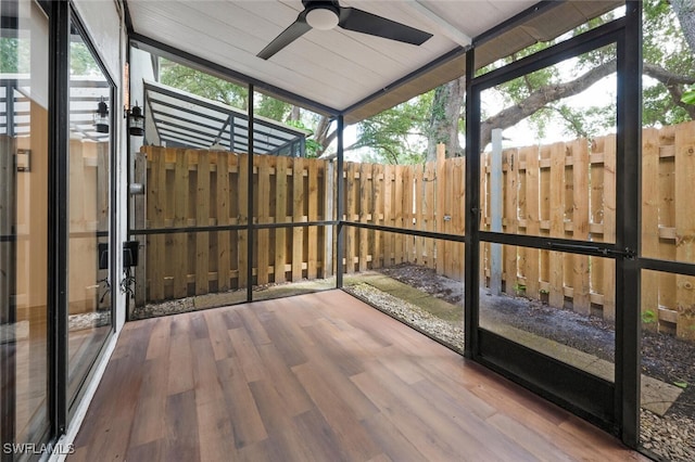 unfurnished sunroom with a ceiling fan and plenty of natural light