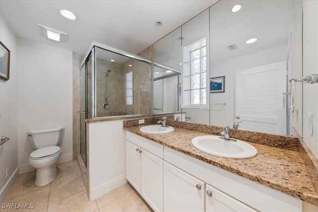 bathroom with tile patterned floors, a shower with door, vanity, and toilet