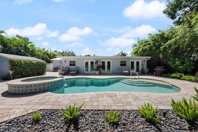 view of swimming pool with french doors, an in ground hot tub, and a patio