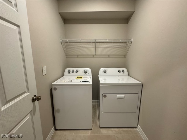 laundry area with independent washer and dryer and light tile patterned flooring