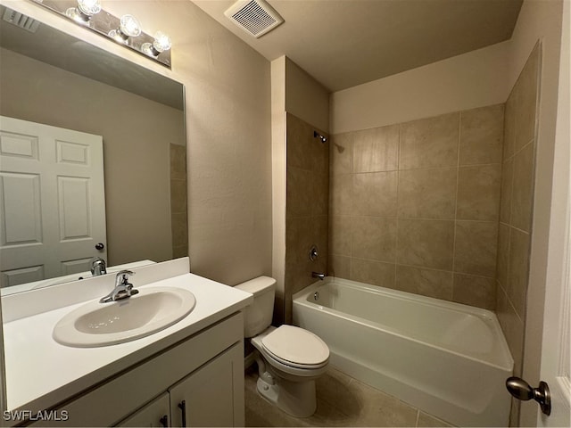 full bathroom with tile patterned flooring, toilet, tiled shower / bath combo, and vanity