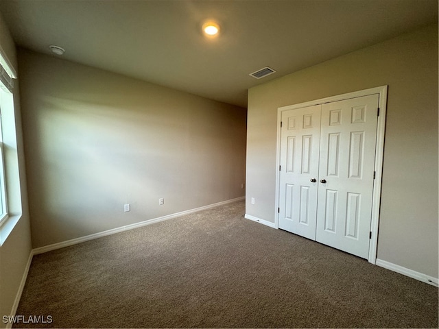 unfurnished bedroom with carpet and a closet