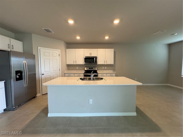 kitchen featuring a kitchen island with sink, appliances with stainless steel finishes, sink, and white cabinets