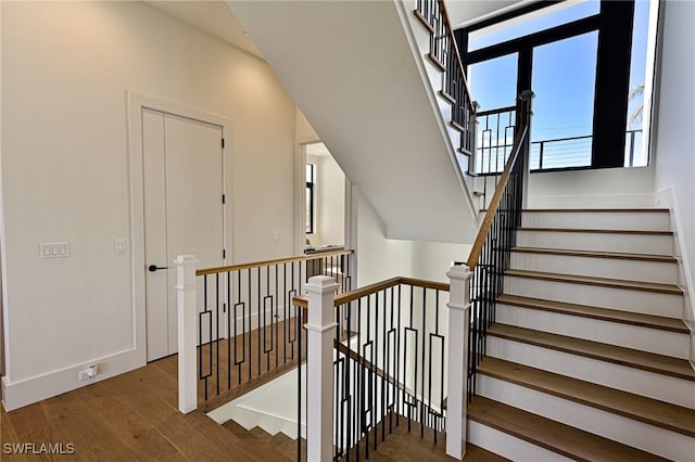 stairway with lofted ceiling and wood-type flooring