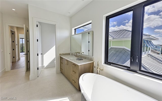 bathroom with plenty of natural light, a bathtub, and vanity