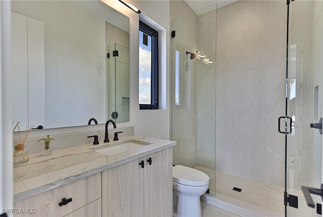 bathroom featuring vanity, an enclosed shower, and toilet