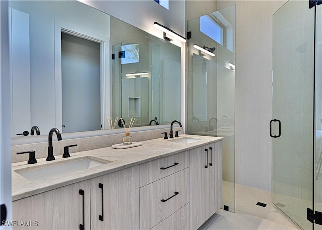 bathroom featuring a shower with door and vanity