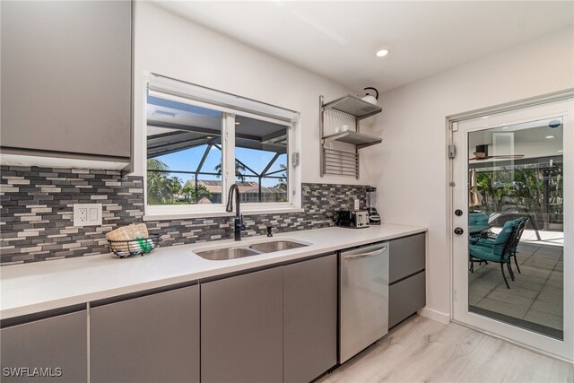 kitchen with dishwasher, sink, gray cabinets, decorative backsplash, and light wood-type flooring