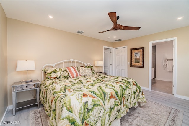 bedroom featuring wood-type flooring, a closet, ensuite bathroom, and ceiling fan