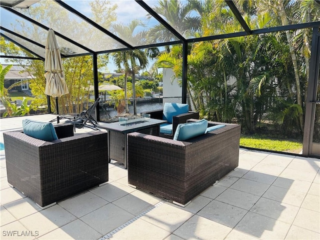 view of patio featuring glass enclosure and an outdoor living space with a fire pit