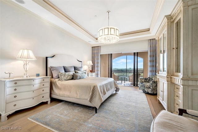 bedroom featuring light hardwood / wood-style flooring, access to exterior, crown molding, and a raised ceiling