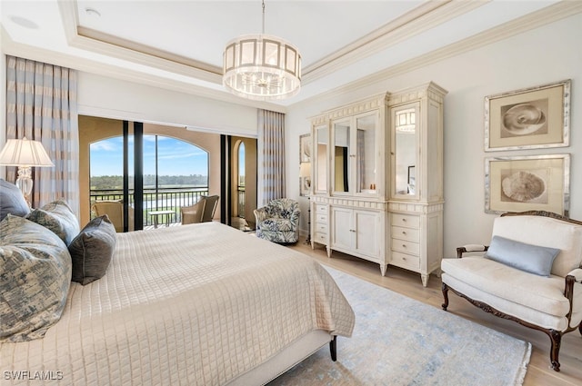 bedroom featuring a tray ceiling, a notable chandelier, access to exterior, and light hardwood / wood-style floors