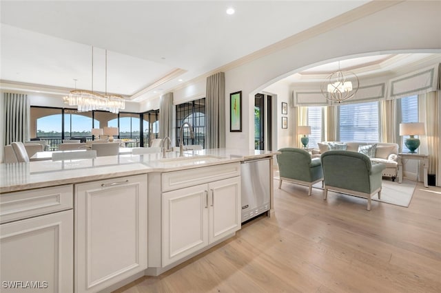 kitchen with light hardwood / wood-style flooring, dishwasher, hanging light fixtures, and a wealth of natural light