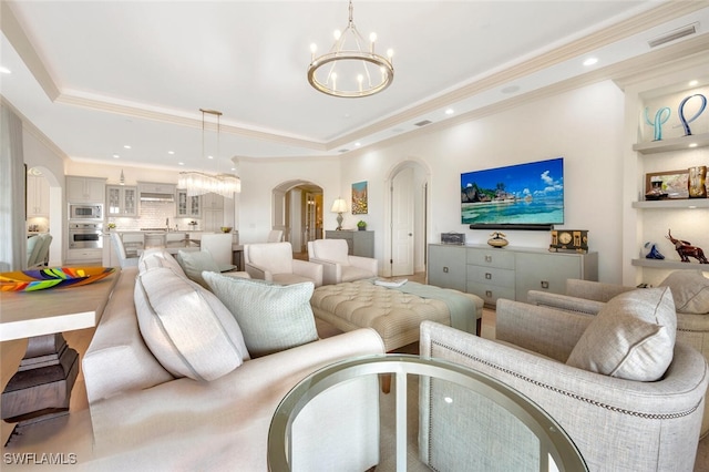 living room with ornamental molding and a tray ceiling