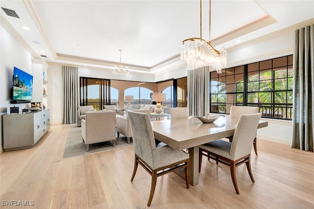 dining area featuring light hardwood / wood-style floors and a tray ceiling