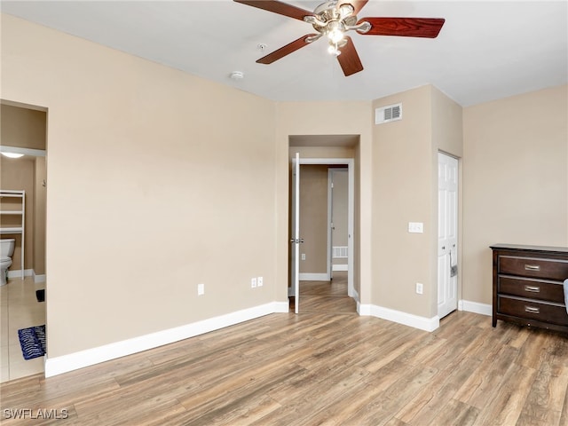 unfurnished bedroom featuring ceiling fan, ensuite bathroom, a closet, and light hardwood / wood-style flooring