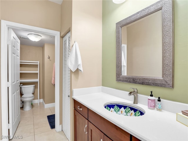 bathroom featuring toilet, vanity, and tile patterned flooring