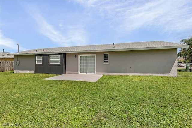 back of house with a patio area and a lawn