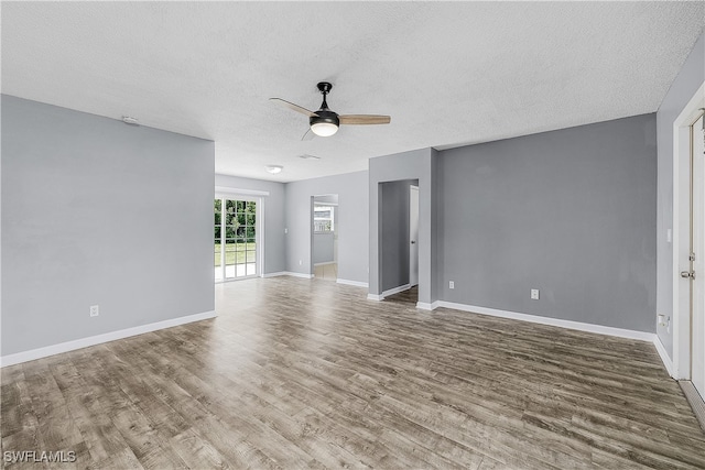 unfurnished room with a textured ceiling, wood-type flooring, and ceiling fan