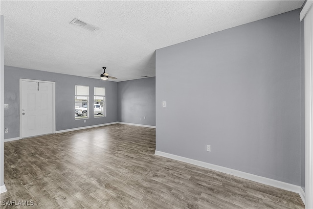 spare room with a textured ceiling, light hardwood / wood-style flooring, and ceiling fan